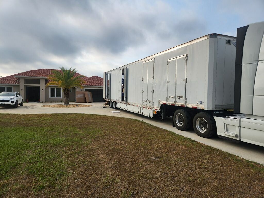 A large white truck is parked in front of a house.