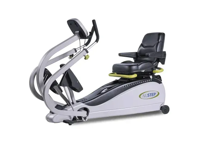 NuStep seated elliptical exercise machine, silver and black, in a studio setting.