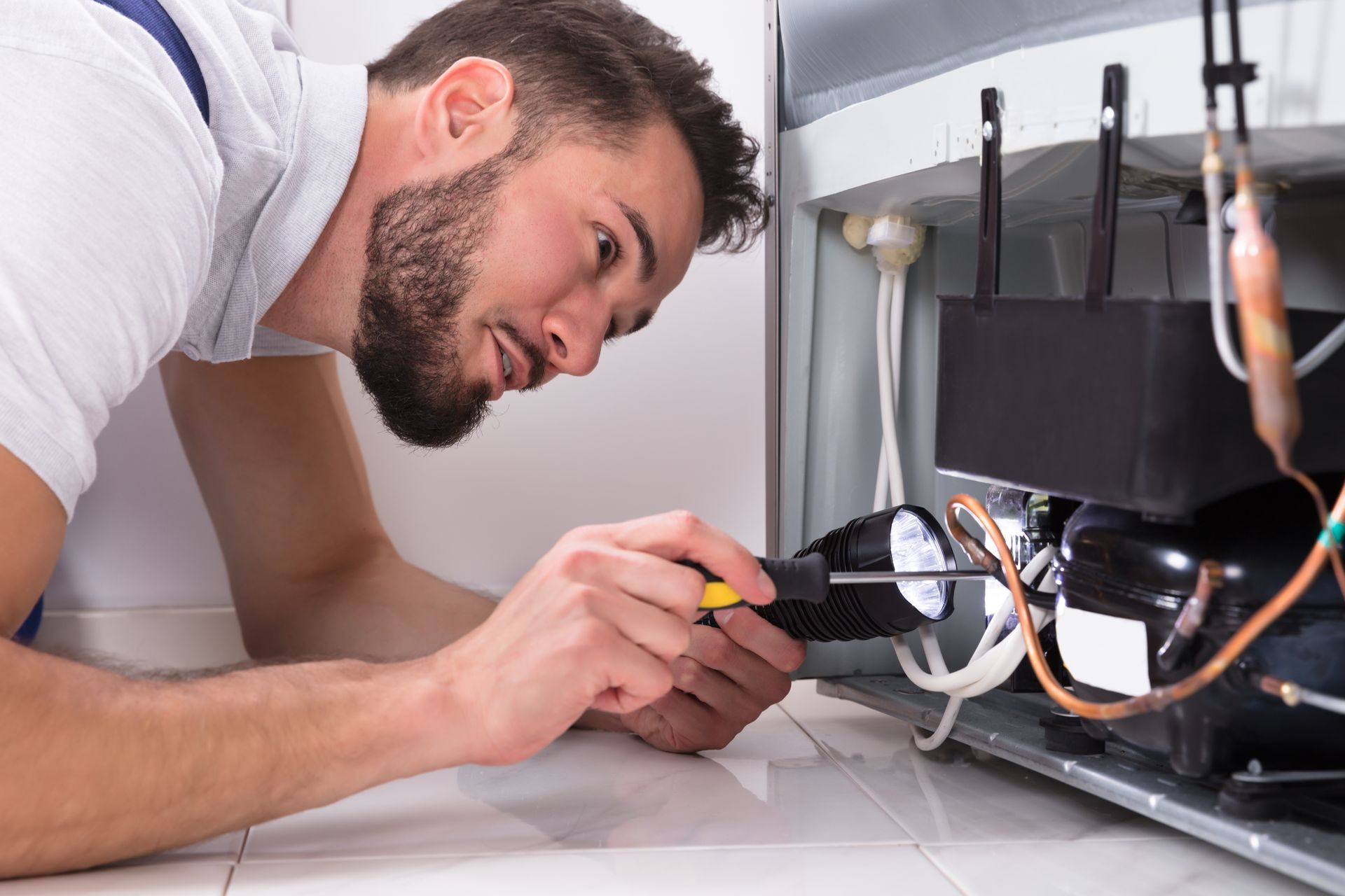 A technician repairing a refrigerator.