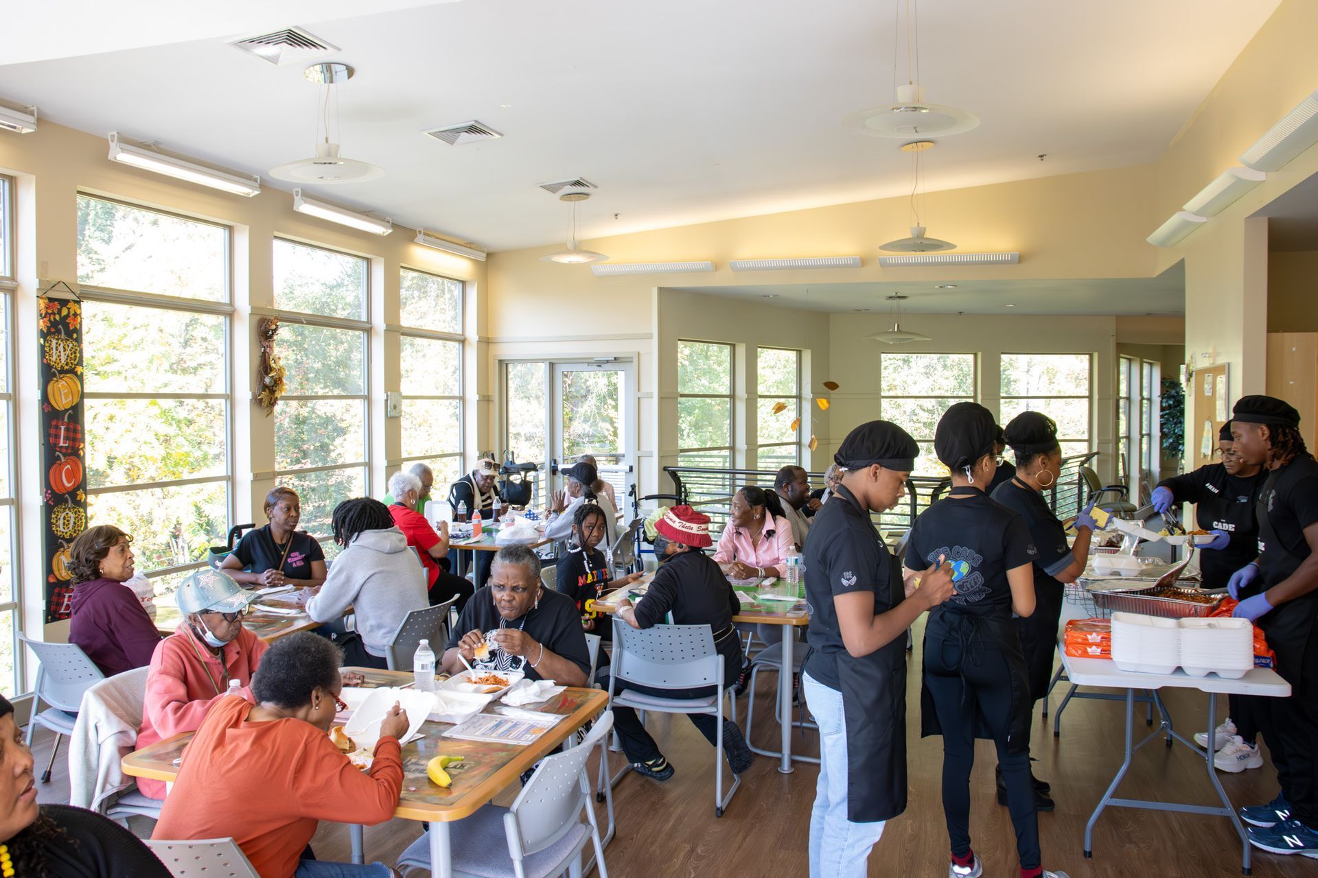 A large group of people are sitting at tables in a dining room.