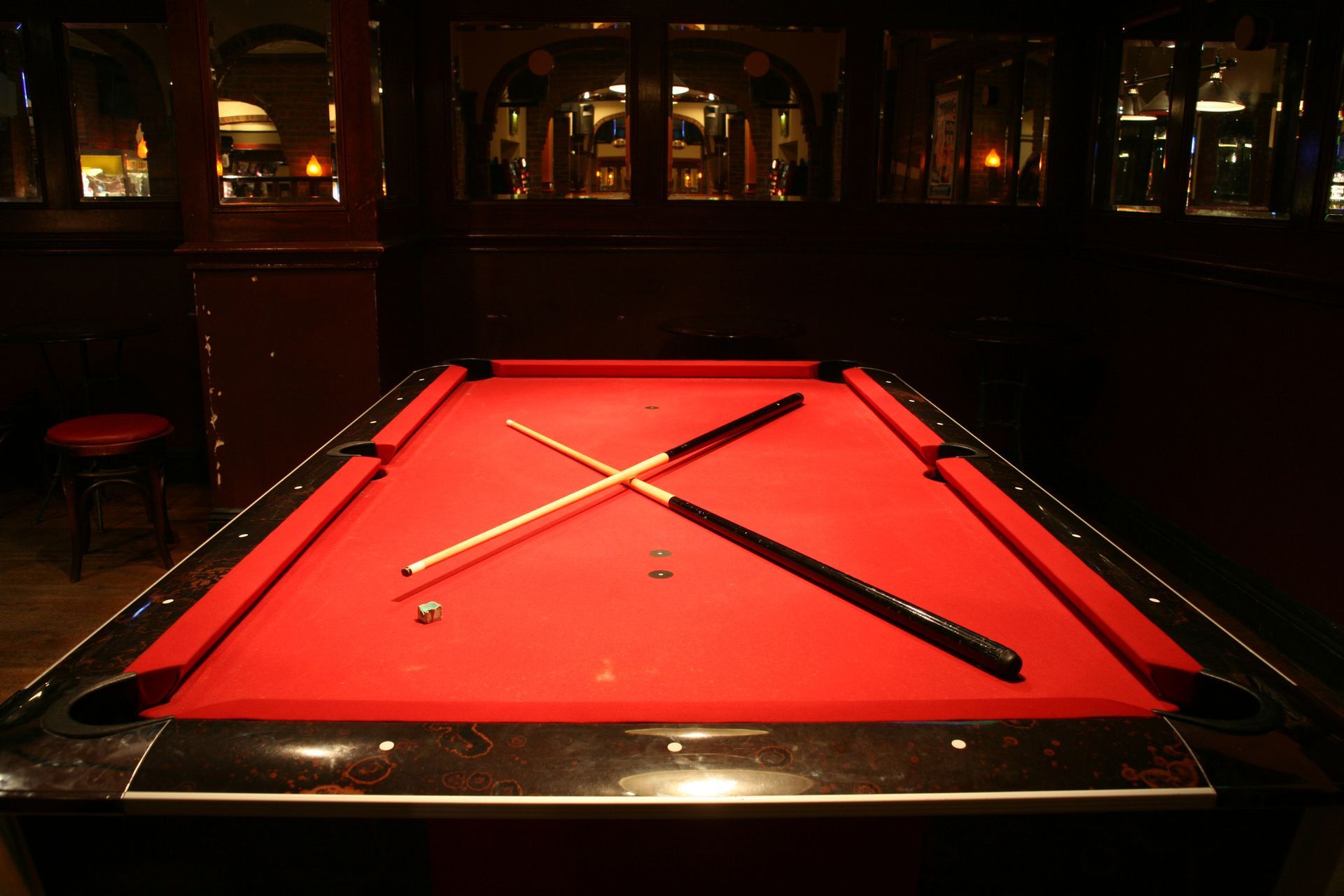 A pool table with cue sticks and a stickA 