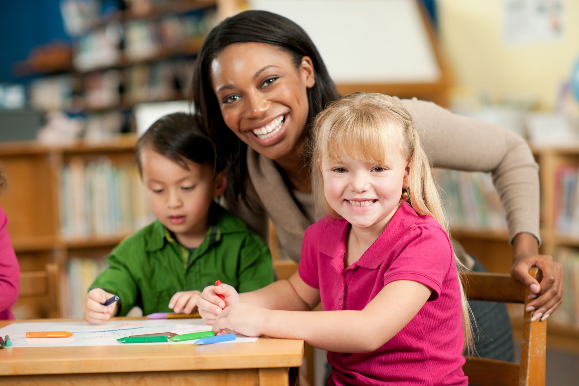 Preschoolers reading in a library with their teacher at Learning Tree Schools | West Jordan, UT