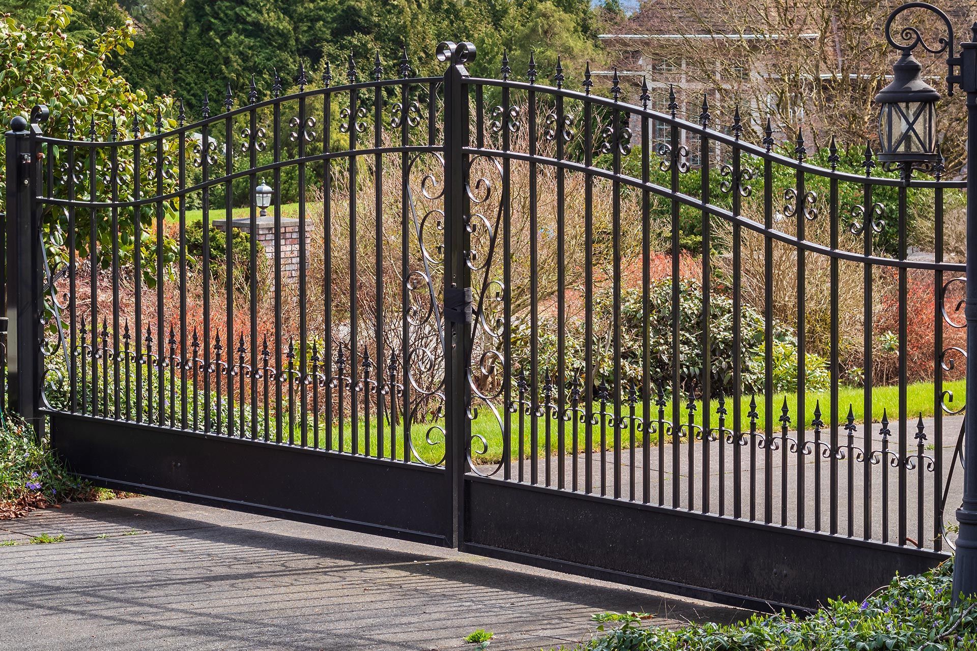 Elegant wrought iron estate gate frames landscaped upscale entry.