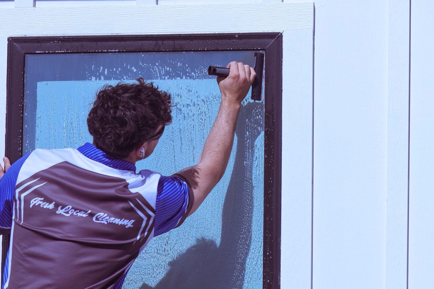 a man is cleaning a window with a squeegee