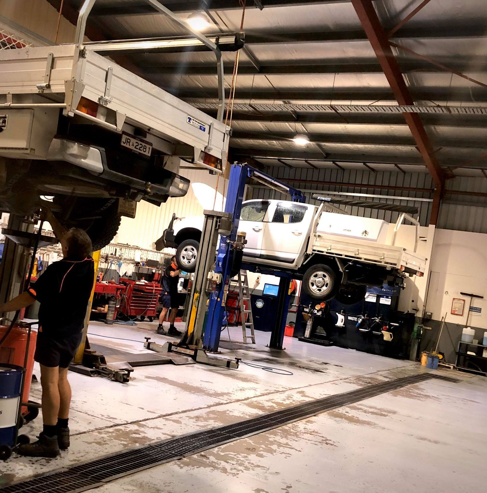 image of a mechanics bay with cars being fixed from underneat
