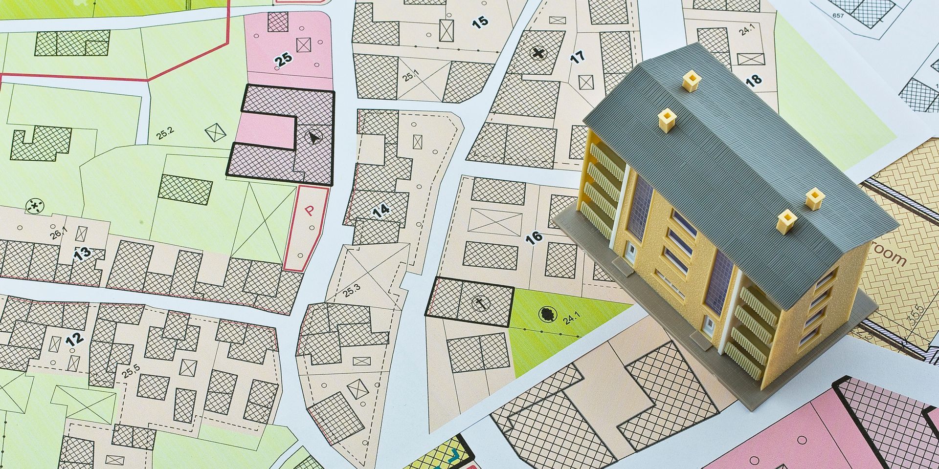 A model house is sitting on top of a map.