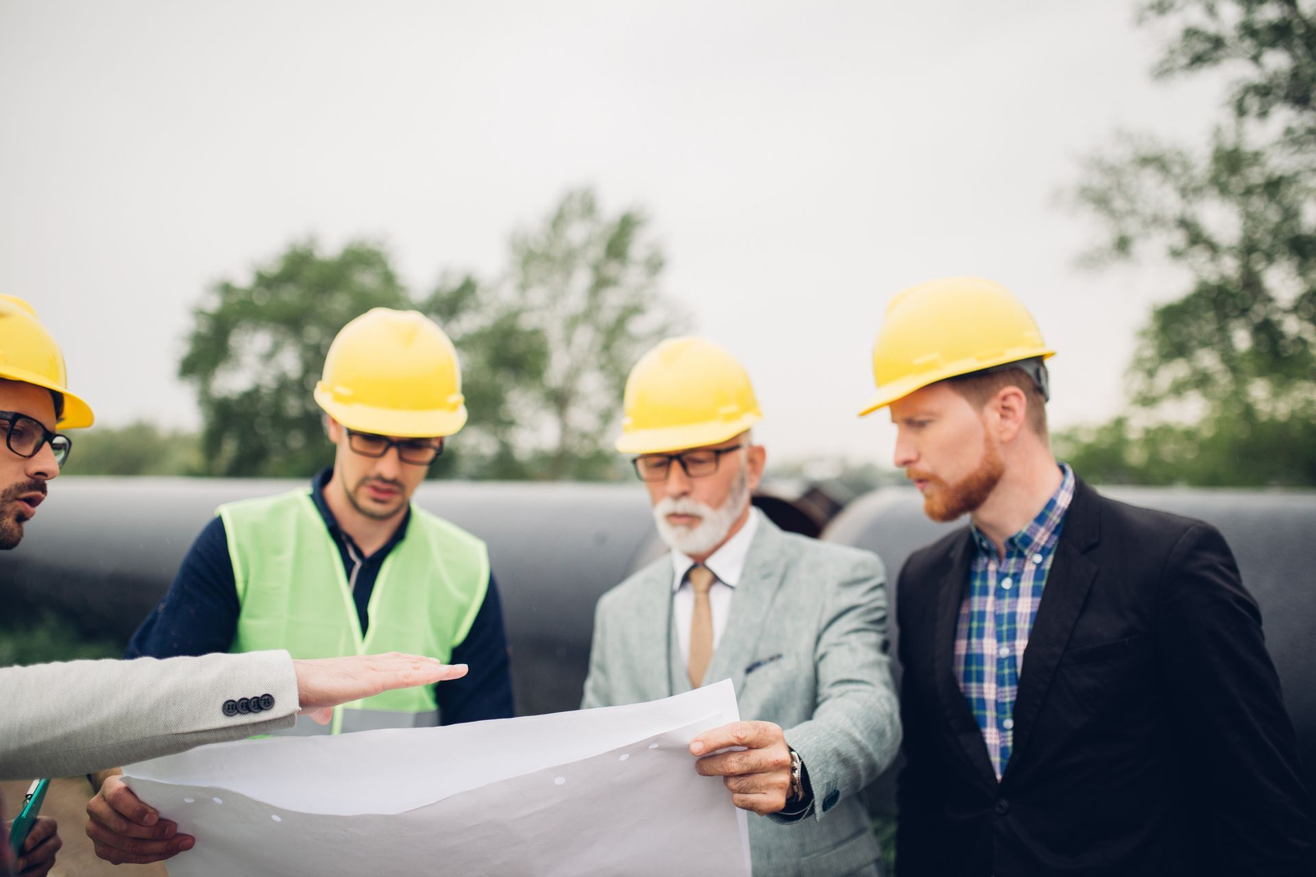 A group of construction workers are looking at a blueprint.