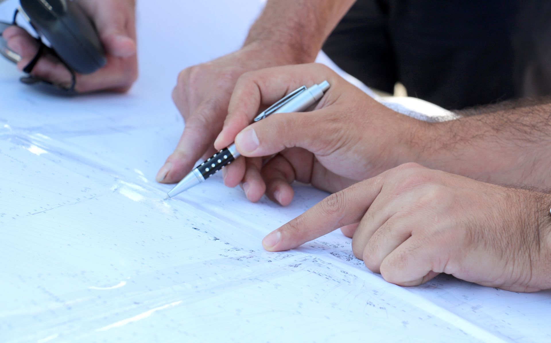 A man is writing on a piece of paper with a pen.