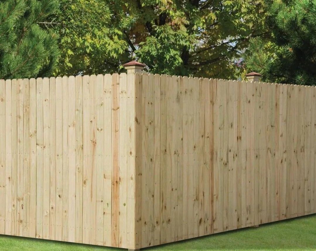 A wooden fence is sitting on top of a lush green lawn.
