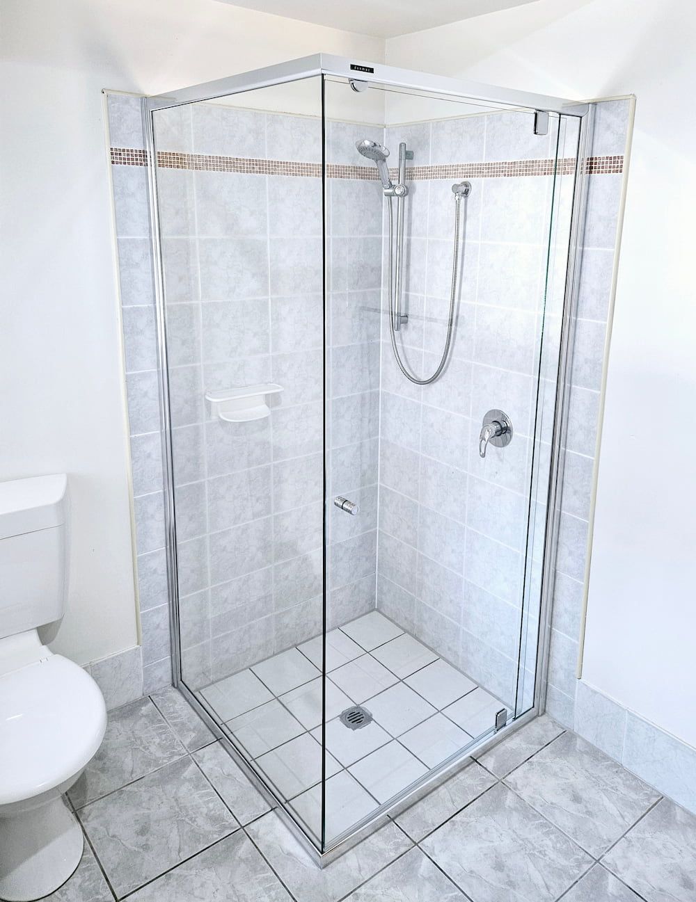 A Bathroom With A Toilet And A Shower With A Glass Door — Mobile Shower Door Doctor In Mountain Creek, QLD