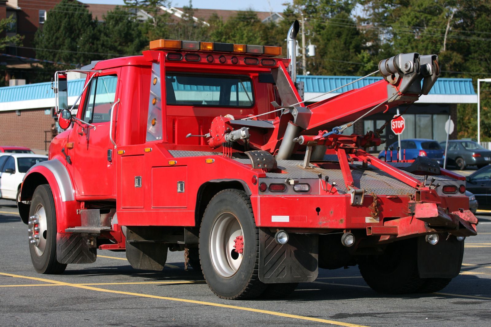 A red tow truck is parked in a parking lot