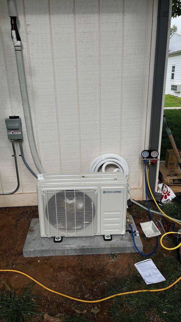 A heat pump unit installed outside a building, with connecting pipes and electrical wiring.