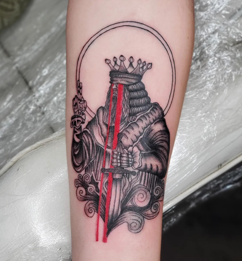 A tattoo of a king with a crown on his head