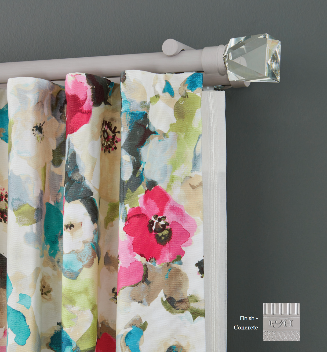 Curtains with colorful floral pattern hanging from a gray rod with a crystal finial.