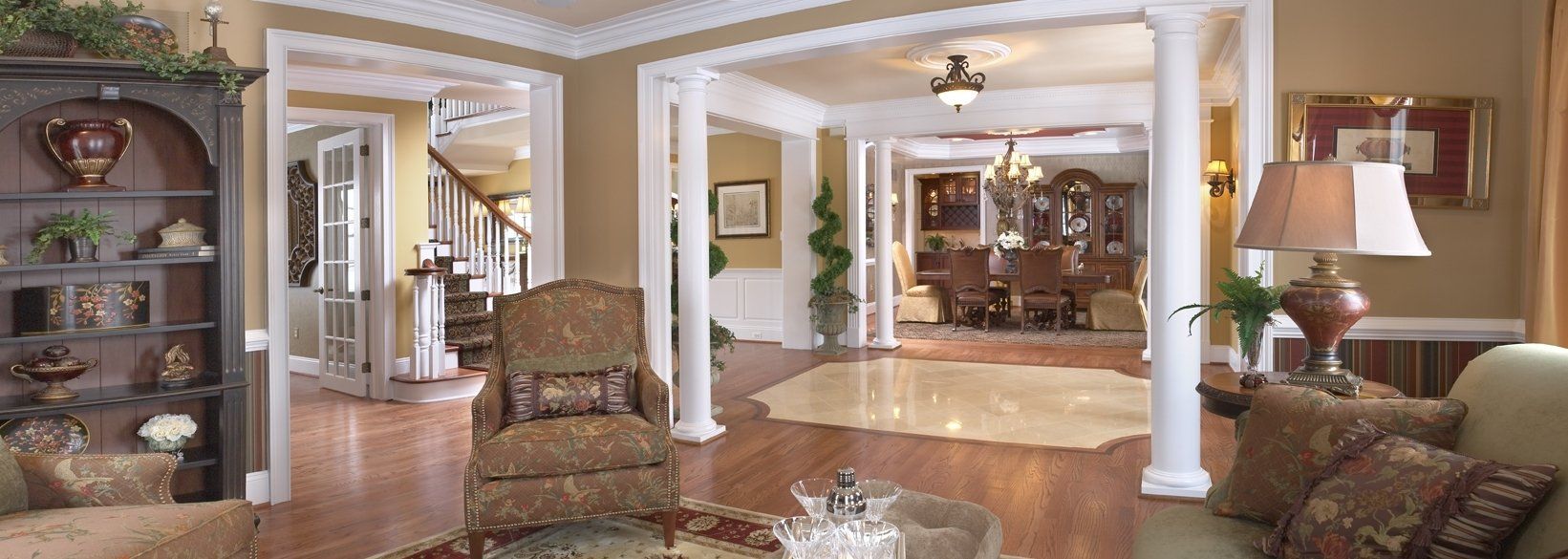 Interior view of a well-lit living room with ornate furnishings and hardwood floors.
