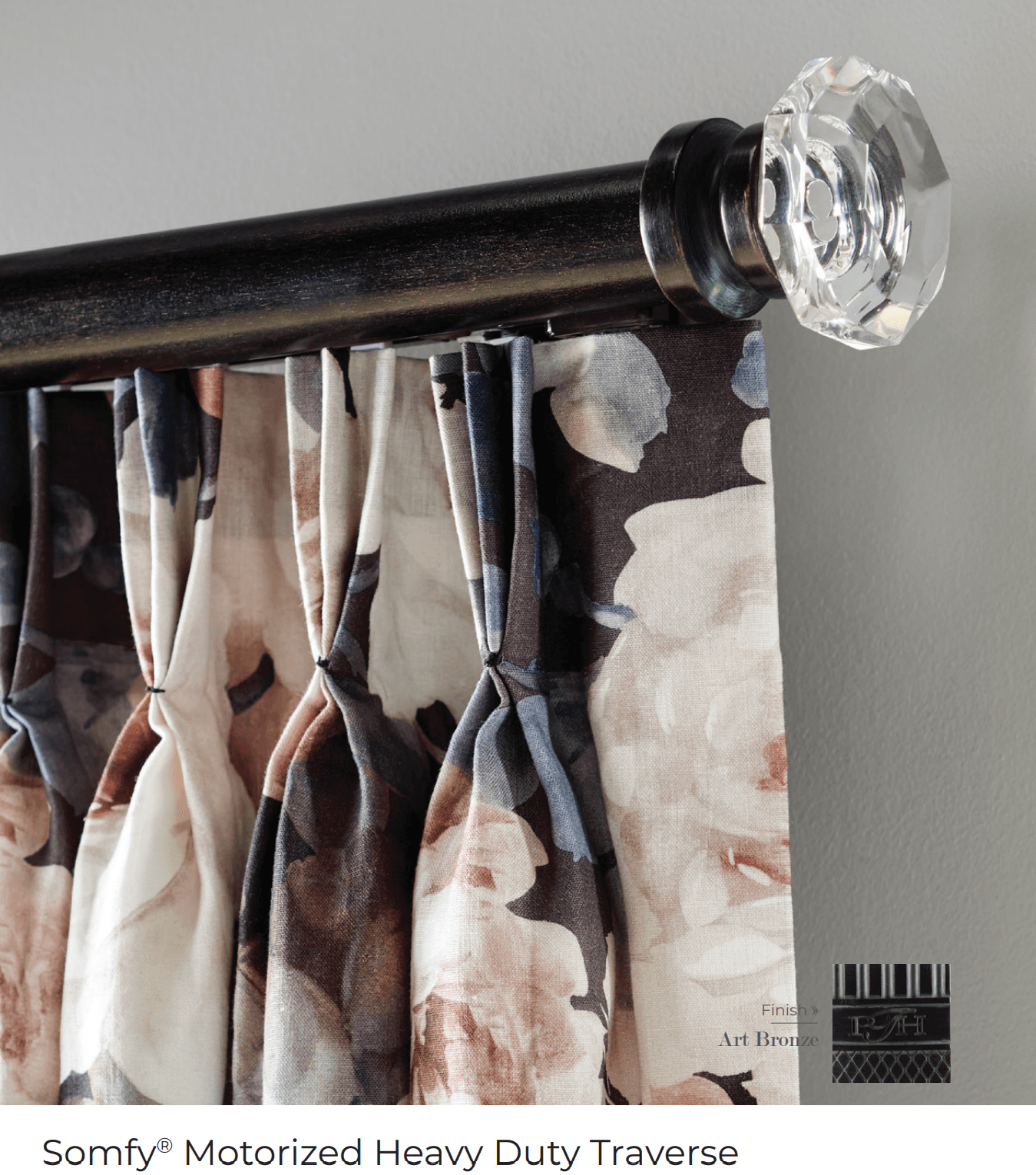 Close-up of a curtain with floral print, hanging from a dark rod with a crystal finial.