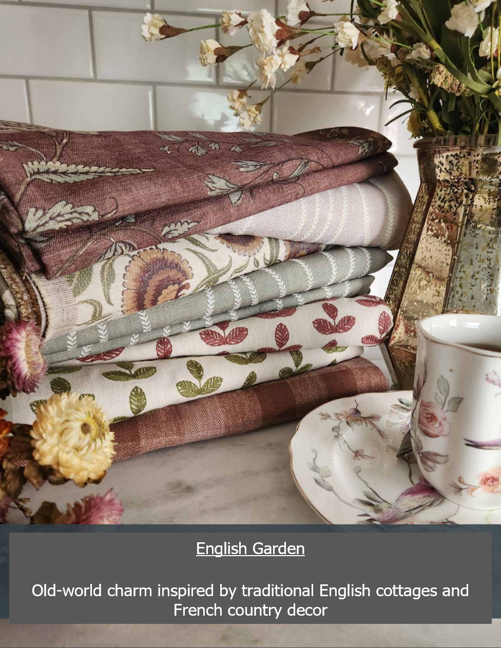 Pile of floral textiles with a teacup and flowers; English Garden theme.