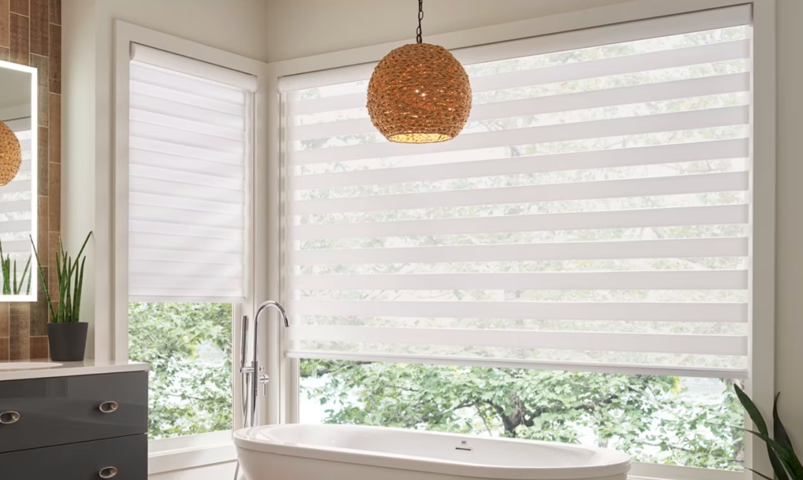 Bathroom with white striped window shades, bathtub, and a woven pendant light.