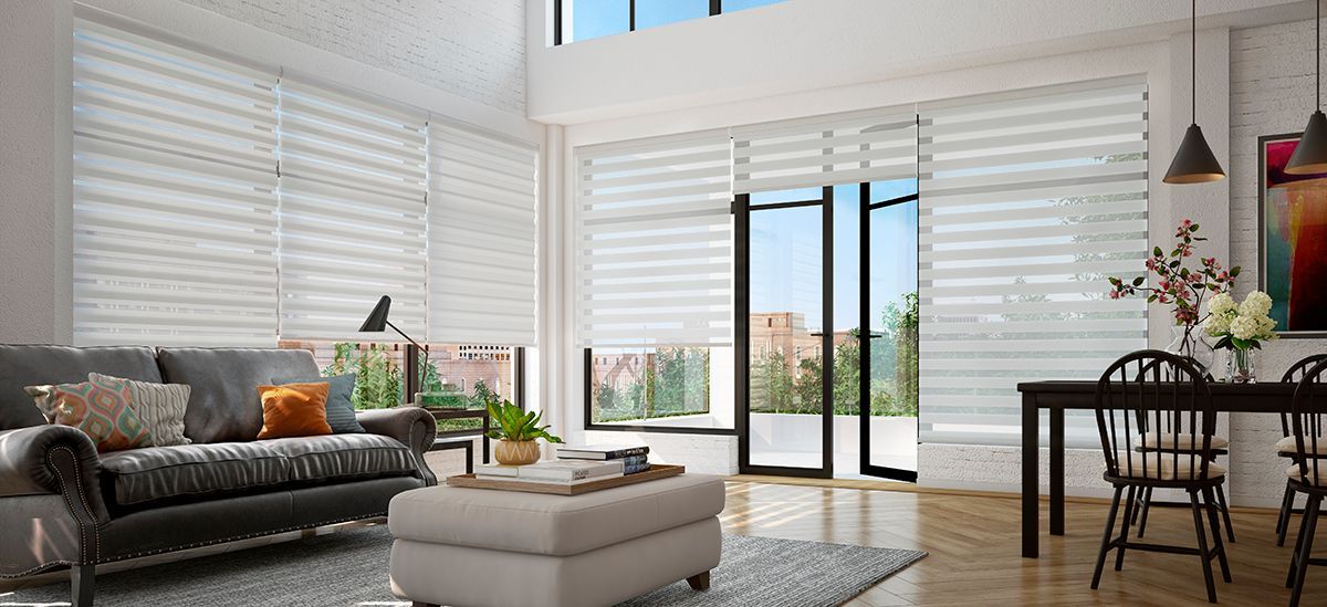 a living room with a gray couch and white blinds