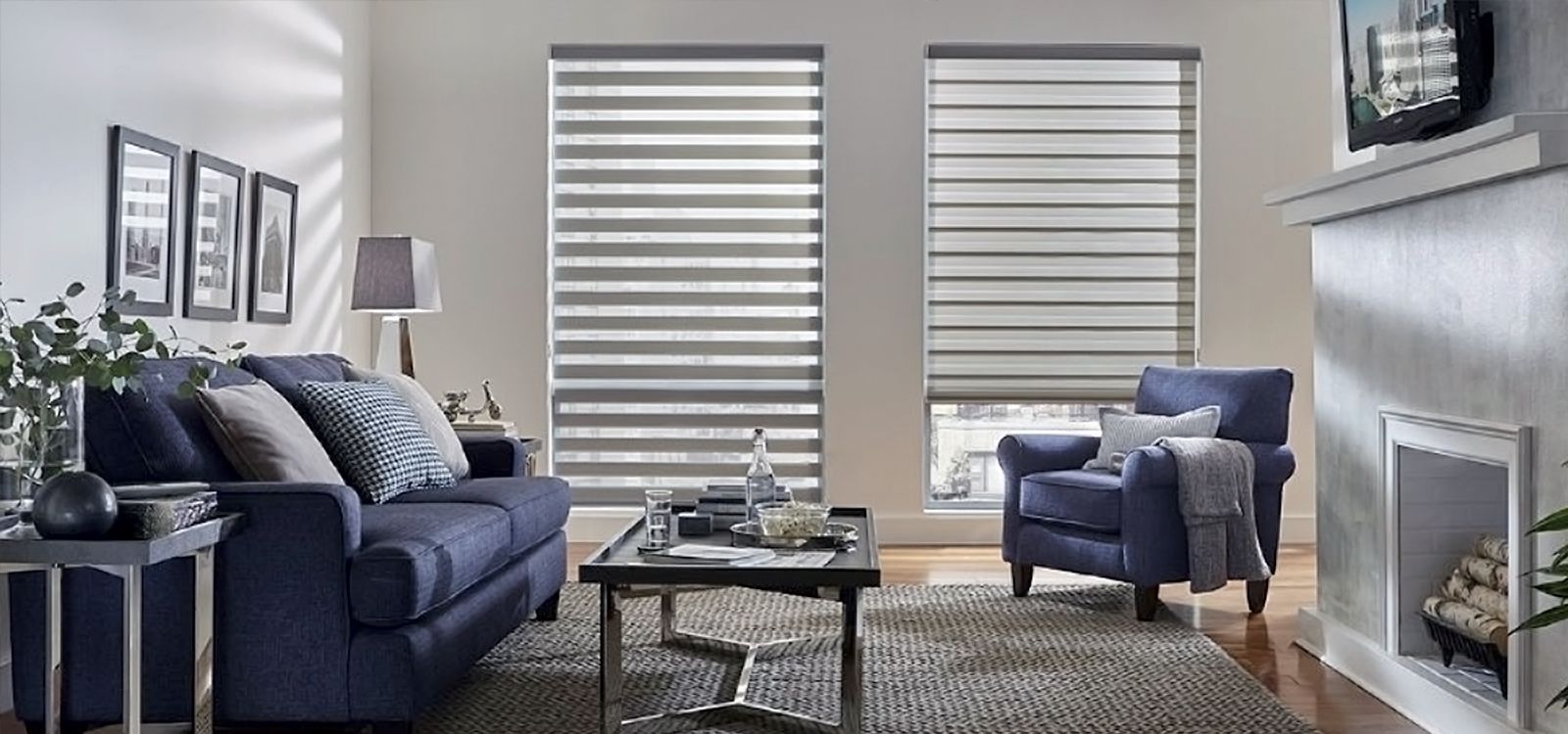 Living room with blue sofa, armchair, fireplace, and window blinds.