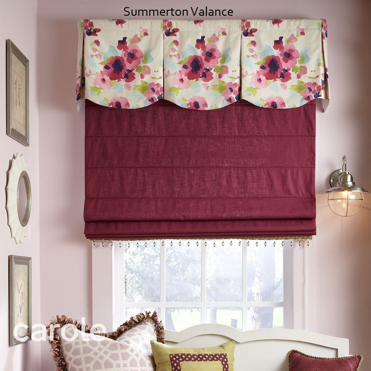 Floral valance over burgundy Roman shade. Window with bed and framed wall art.