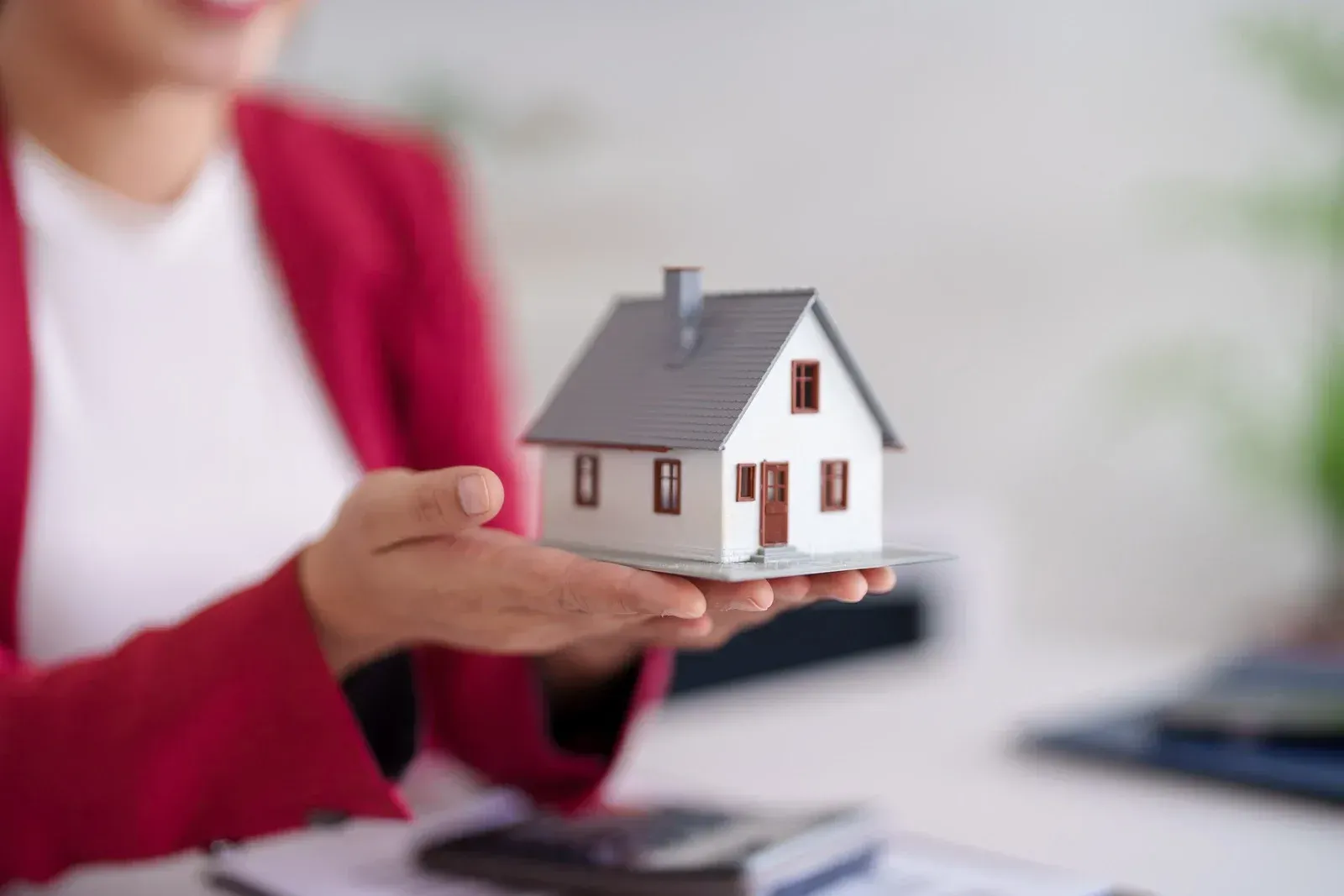 Modern house with grey garage door, white trim, and blue sky. Gravel driveway and green lawn.