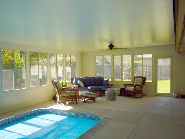 Indoor pool area with pool, seating, and many windows. Light and airy feel.
