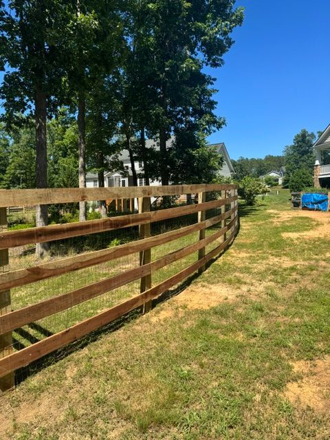 A wooden fence surrounds a grassy field in front of a house — Scottsville, Va — Pbr Grounds Llc