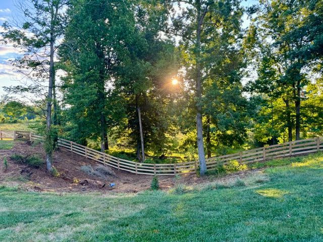 The sun is shining through the trees in a field with a wooden fence | Scottsville, VA | PBR Grounds LLC