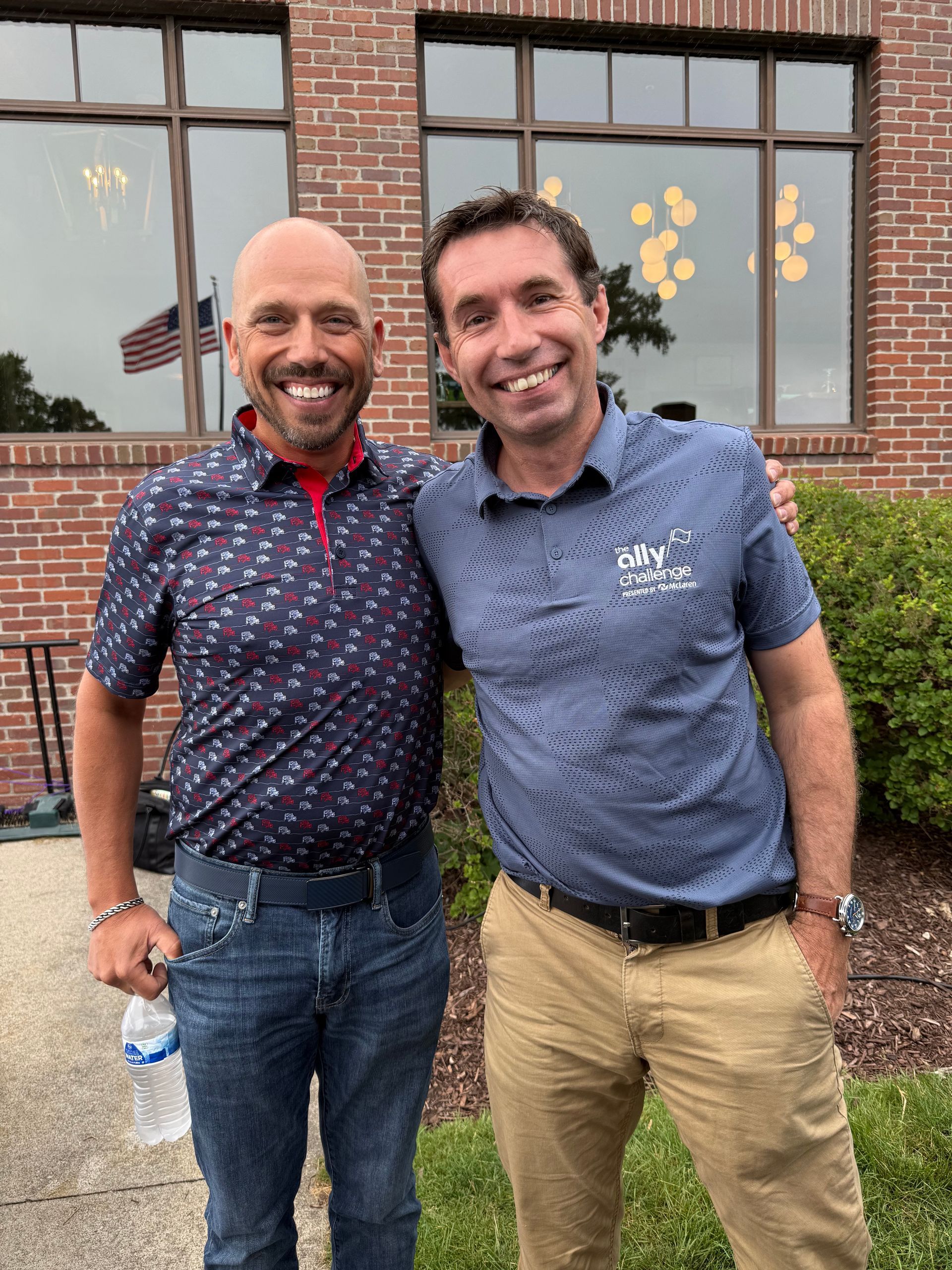 A group of people are posing for a picture in front of a brick wall.