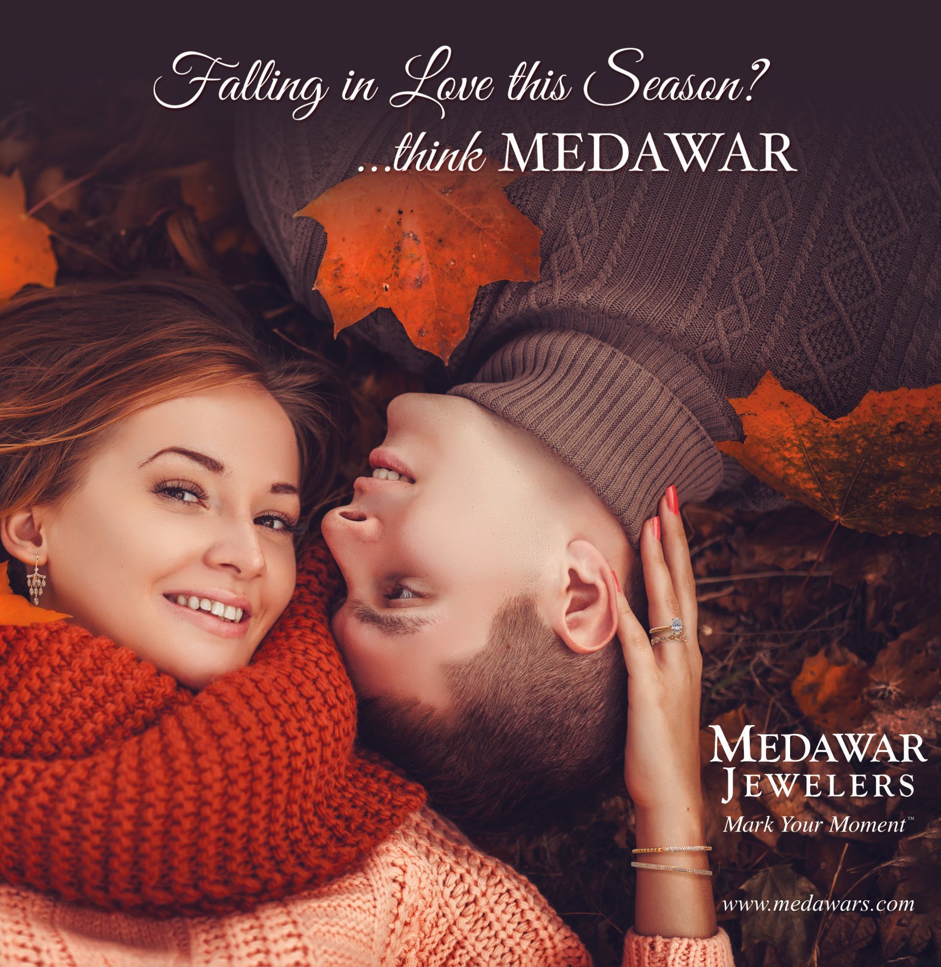 A man and a woman are laying on their backs with leaves in the background