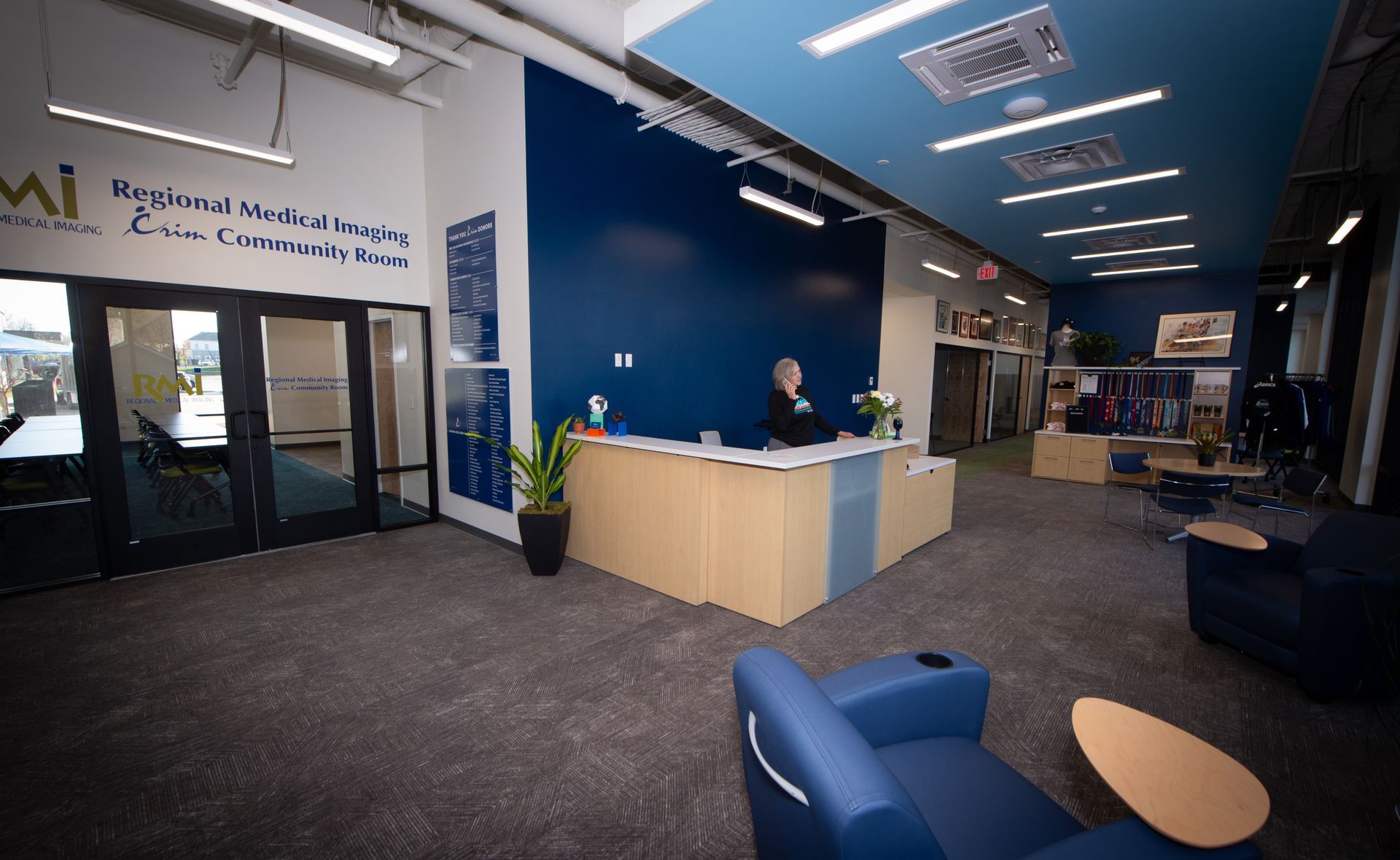 A woman is standing at a reception desk in a lobby.