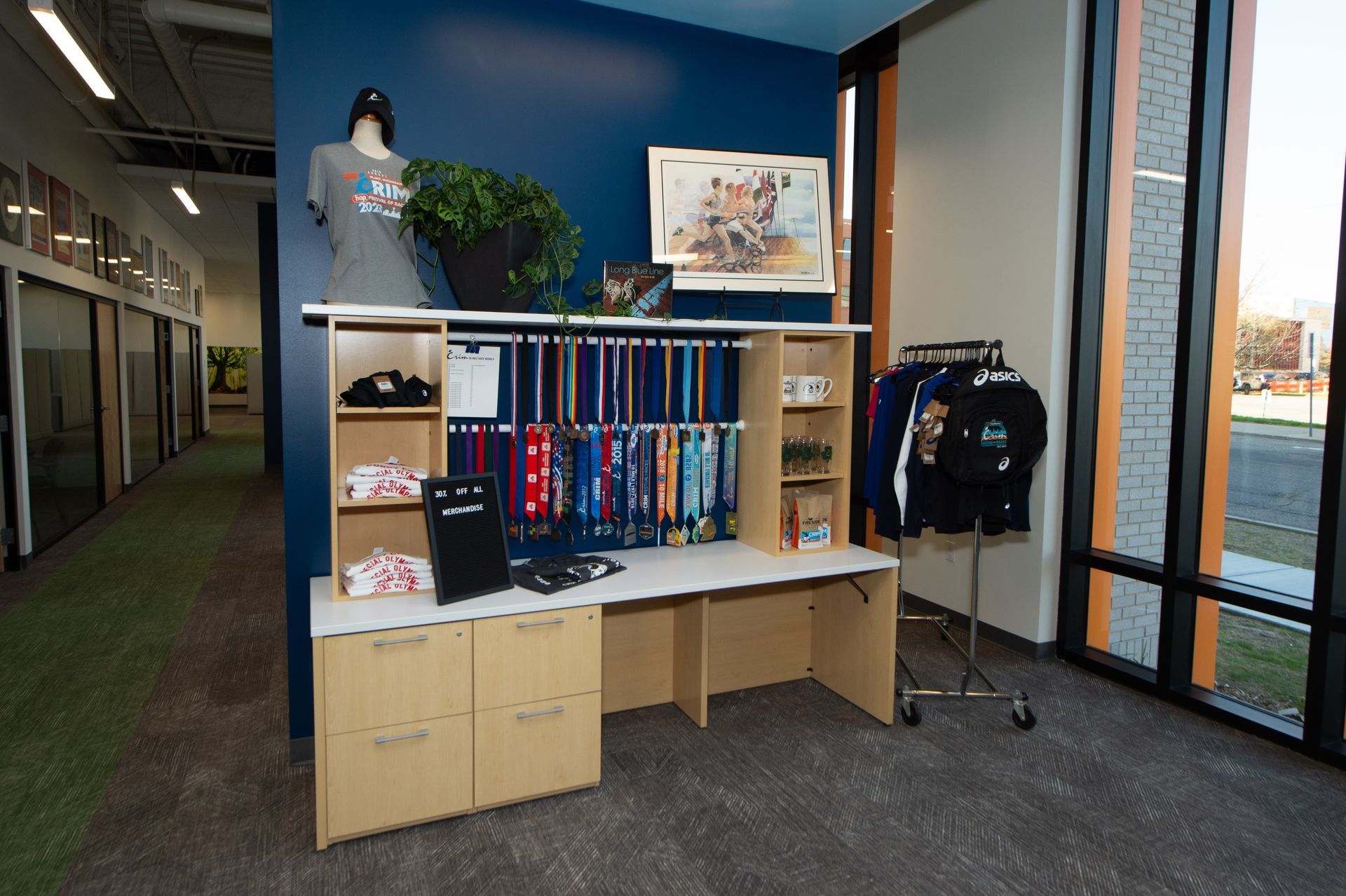 A room with a desk , shelves , and a mannequin.