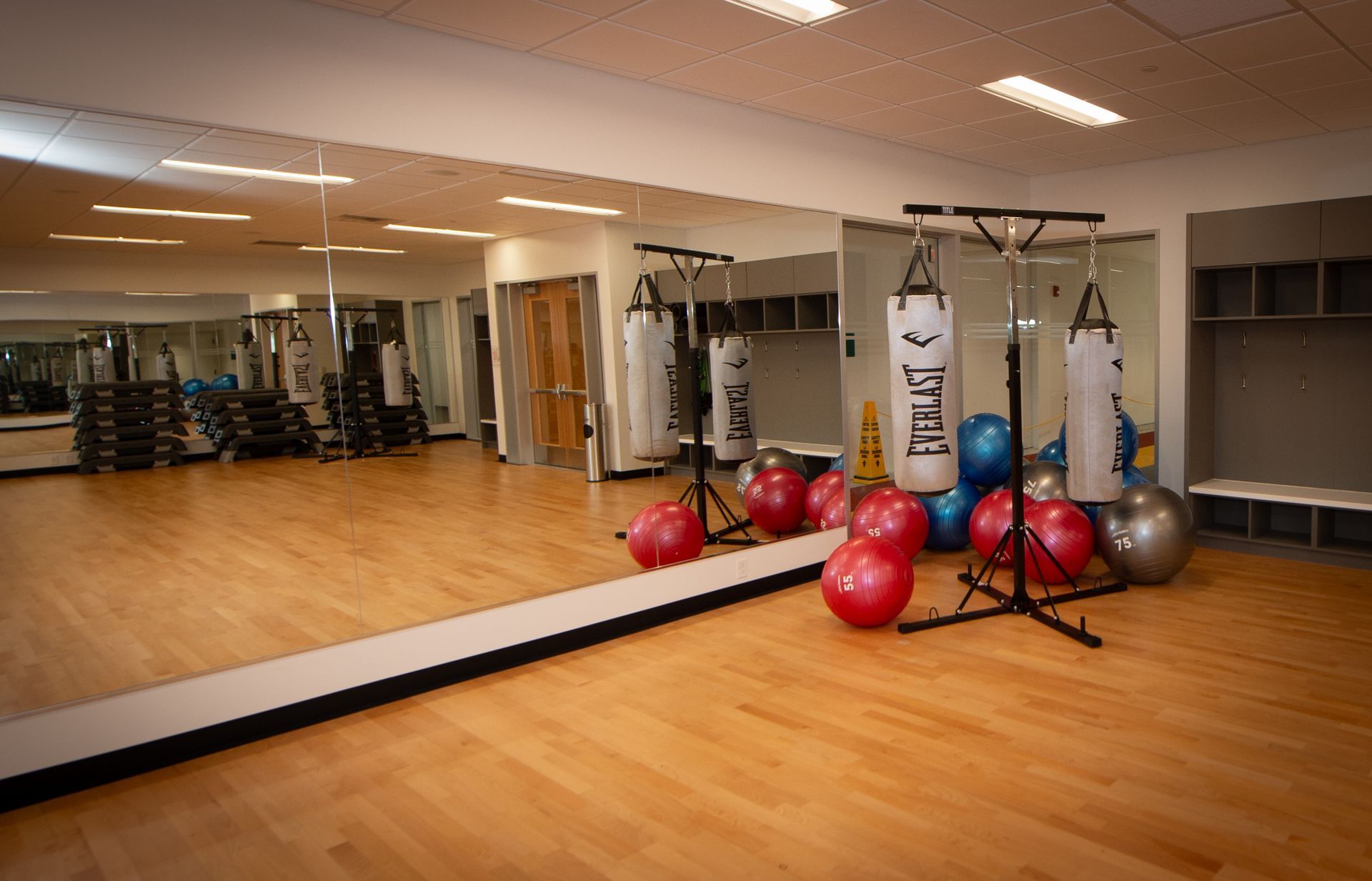 A gym with a lot of exercise equipment and a large mirror