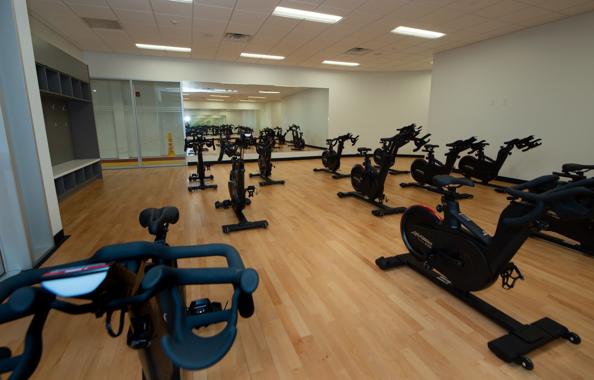 A gym with a lot of exercise bikes on the floor