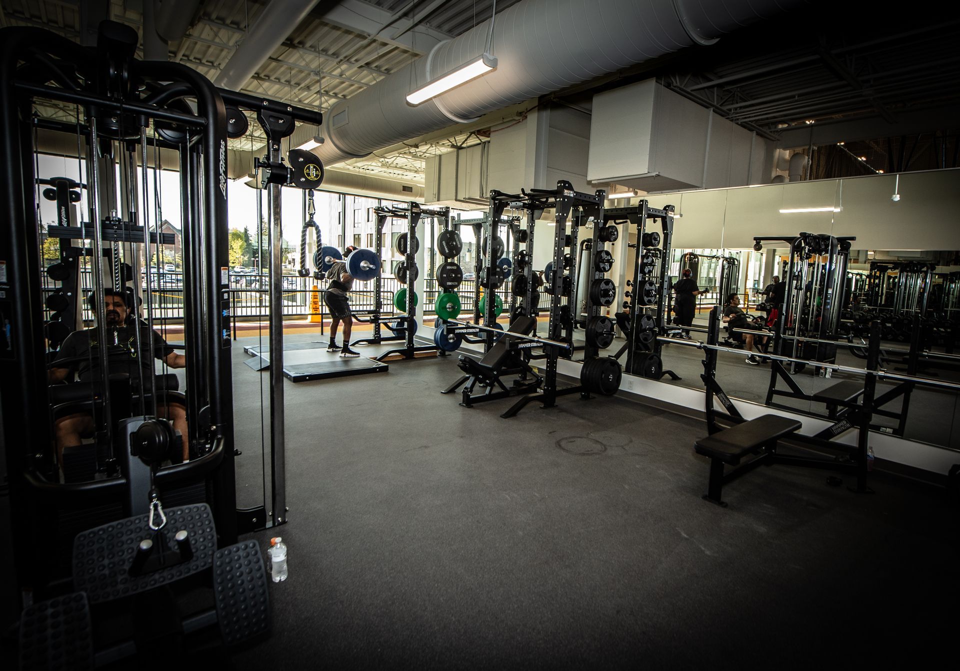 A gym filled with lots of exercise equipment and people.