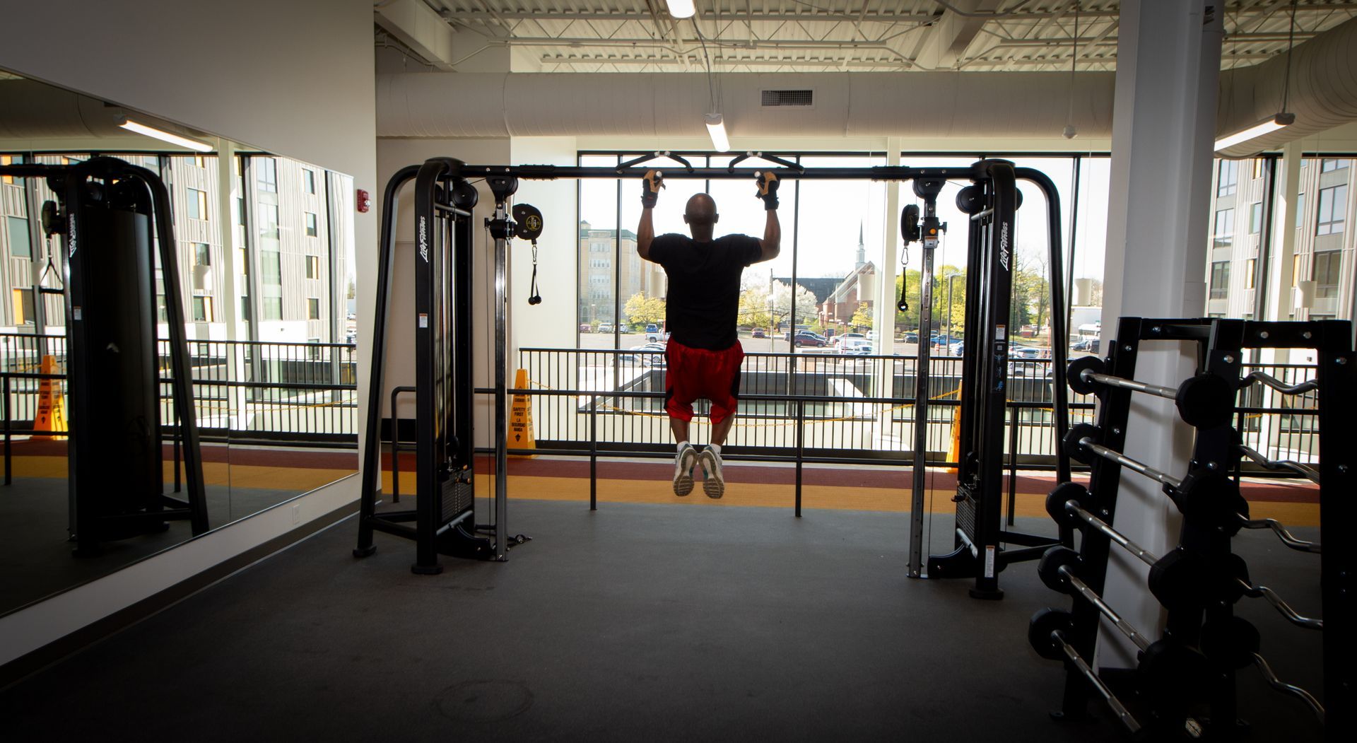 A man is doing pull ups in a gym