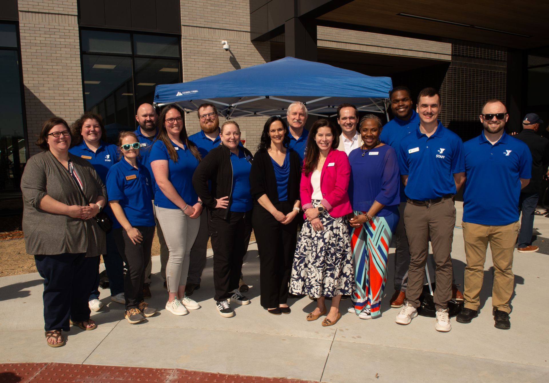 A group of people are posing for a picture in front of a building.