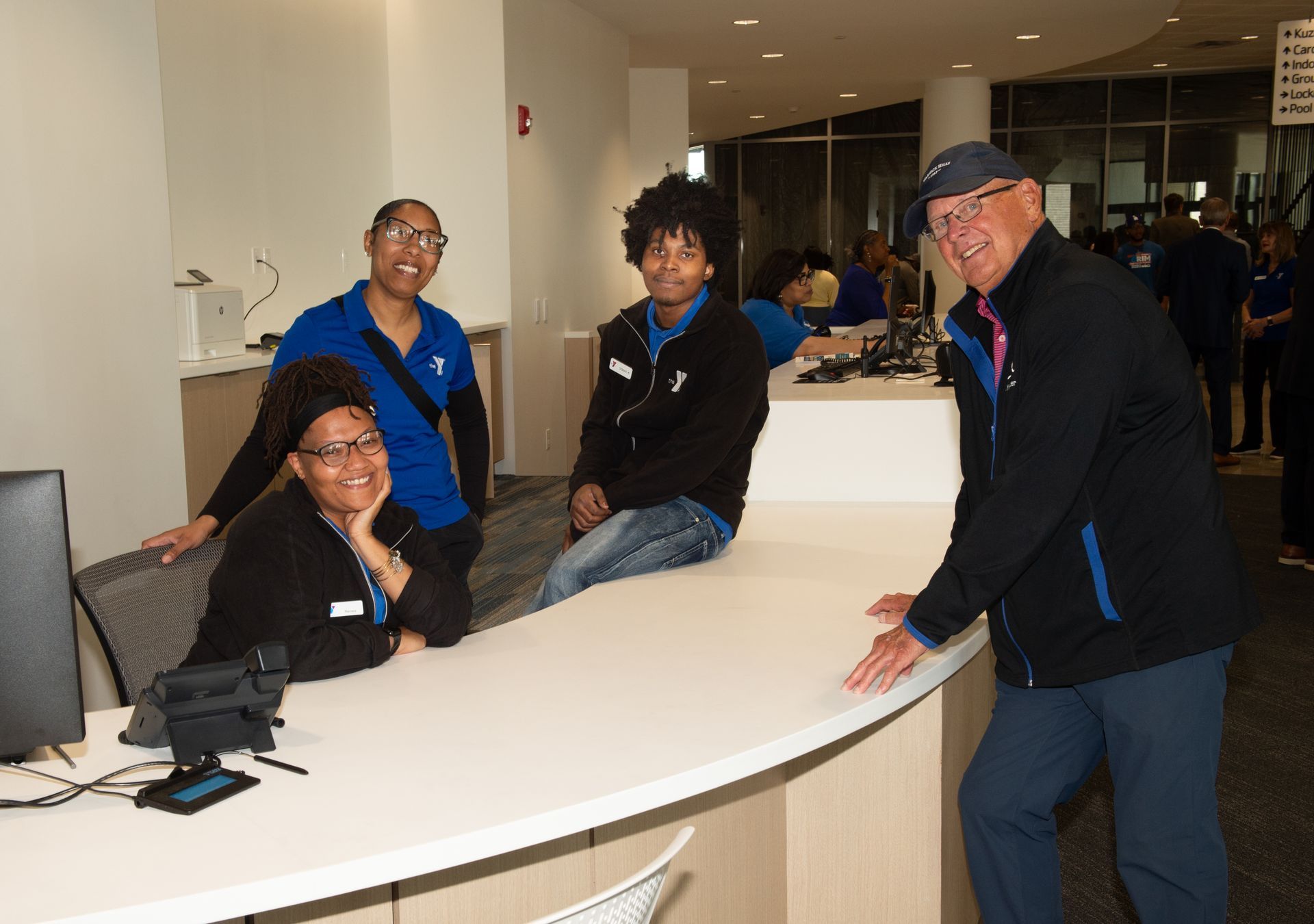 A group of people are standing around a counter in an office.