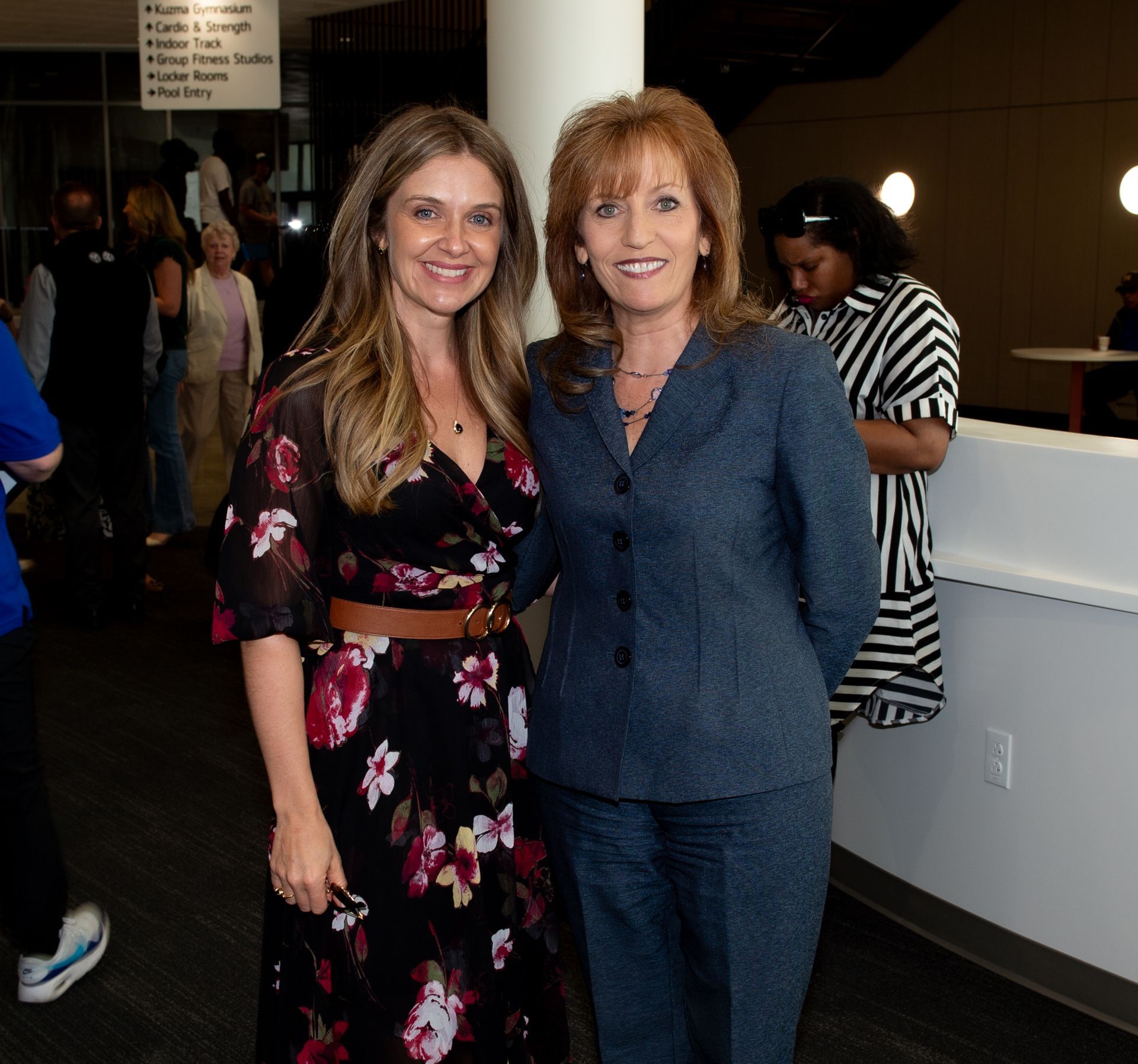 Two women are posing for a picture and one is wearing a floral dress