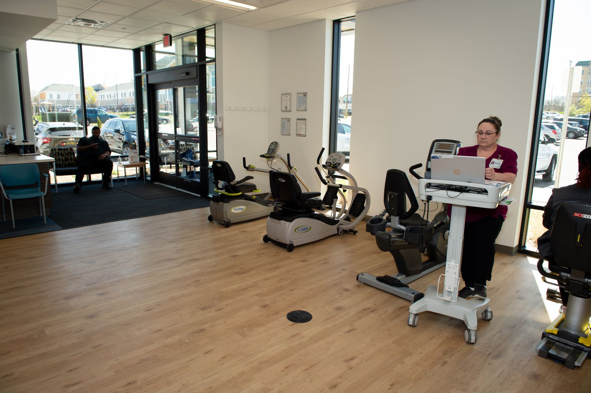 A woman is sitting on an exercise bike in a gym.