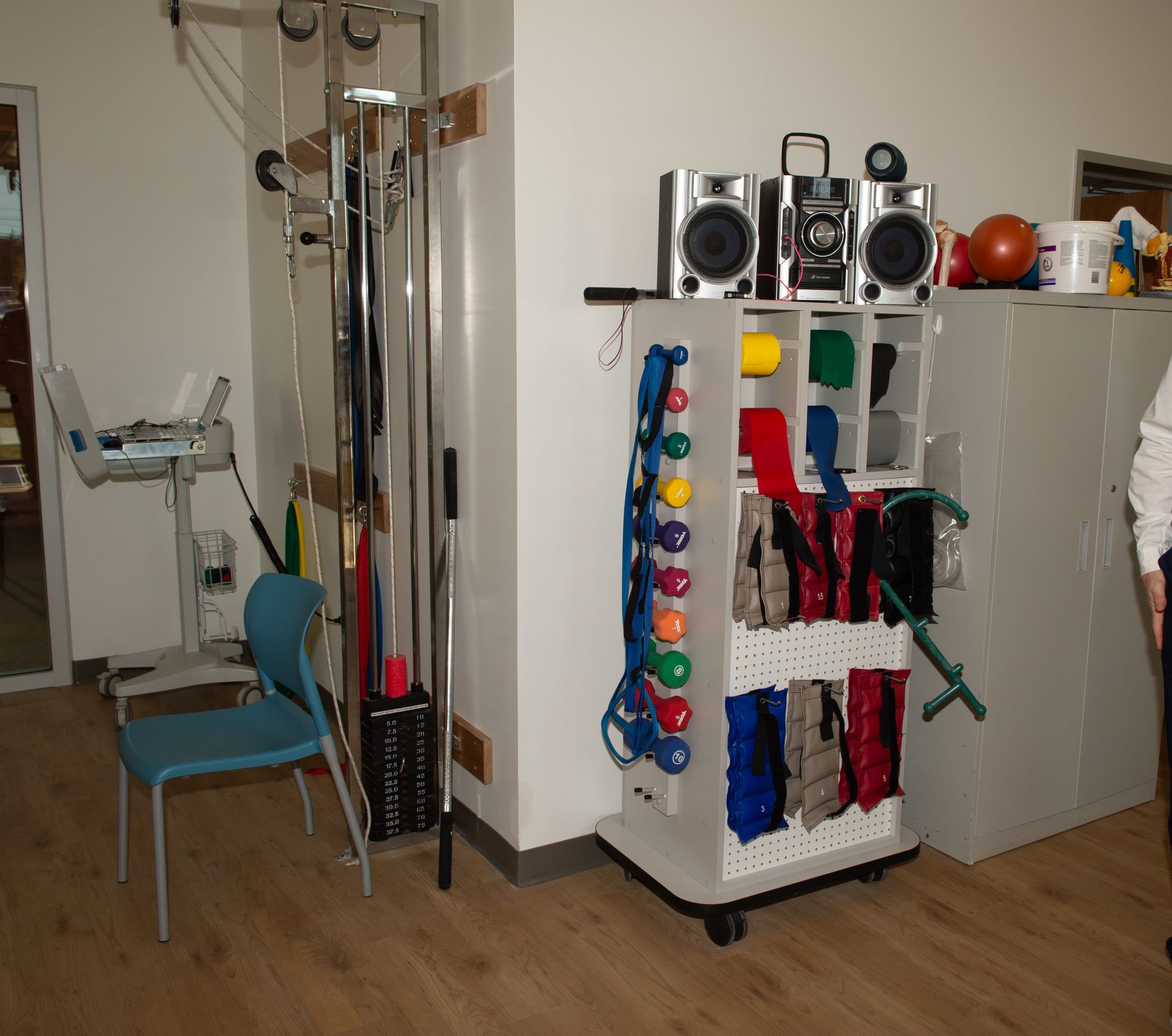 A room with a cart full of exercise equipment and speakers
