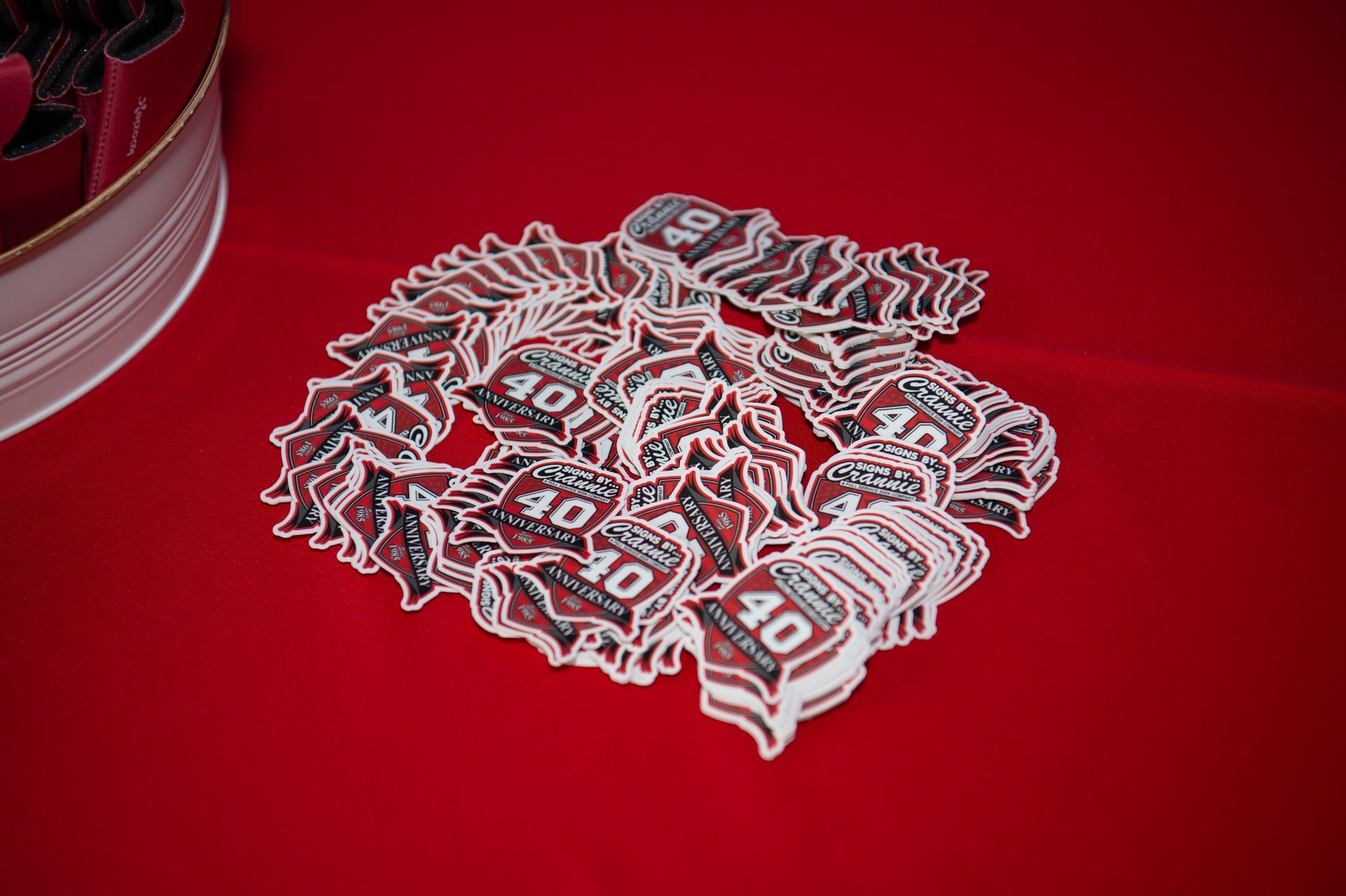 A bunch of stickers are stacked on top of each other on a red surface.