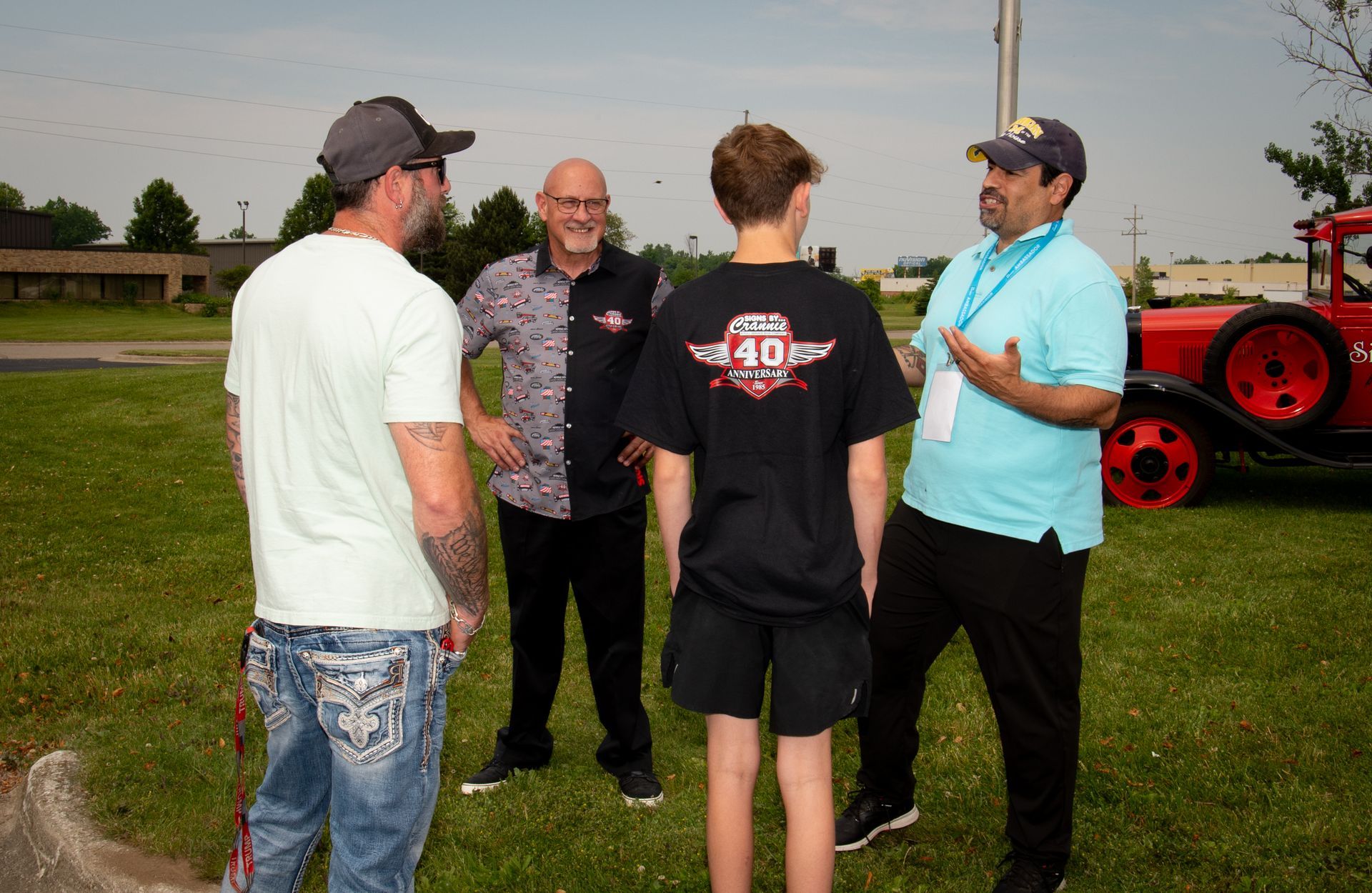 A group of men are standing in a grassy field talking to each other.