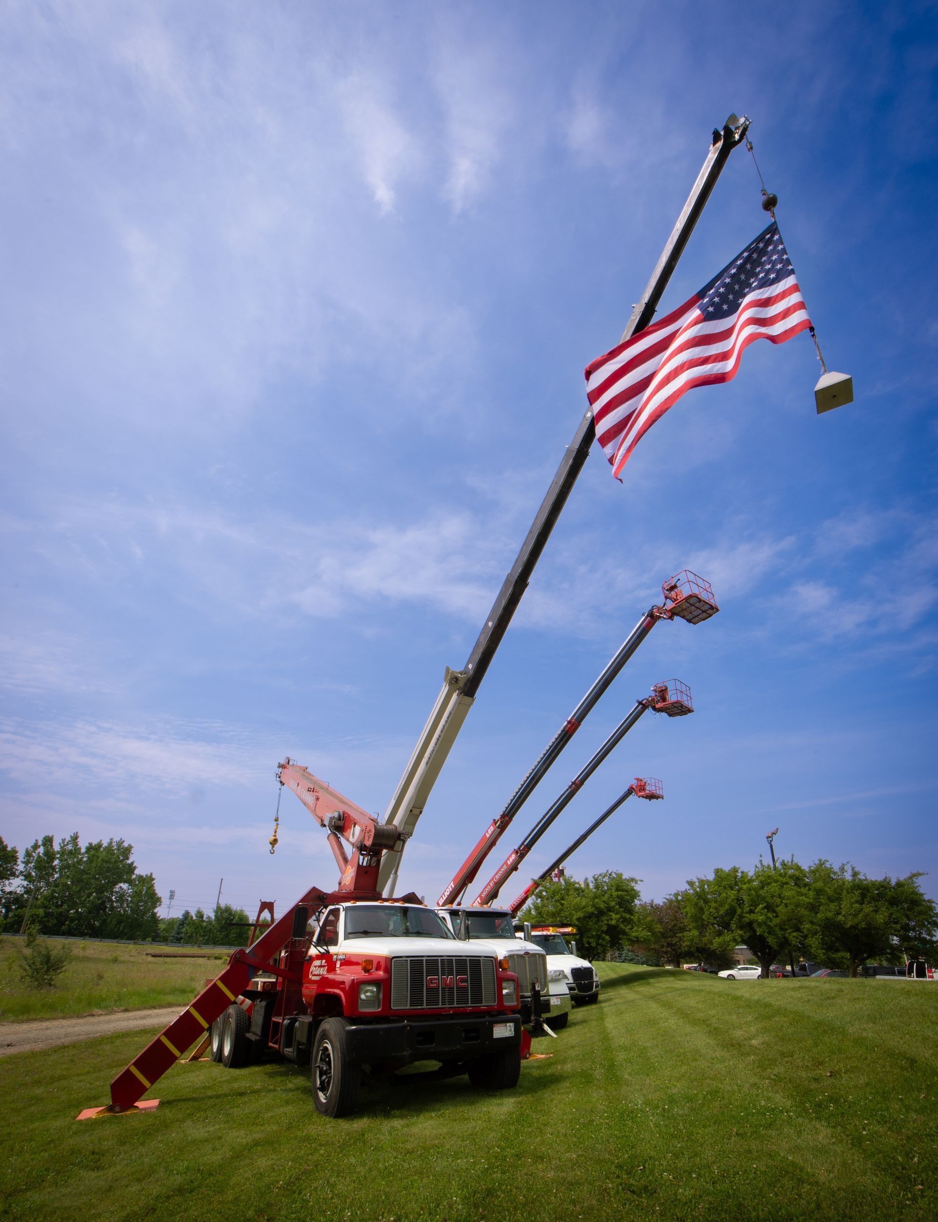 A row of trucks with american flags on top of them