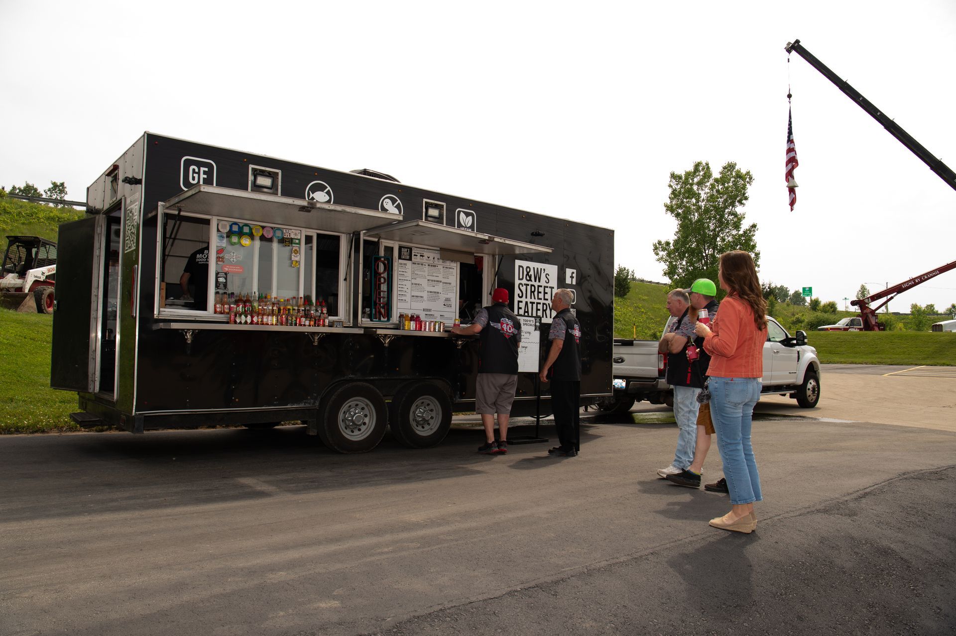 A group of people are standing in front of a food truck.