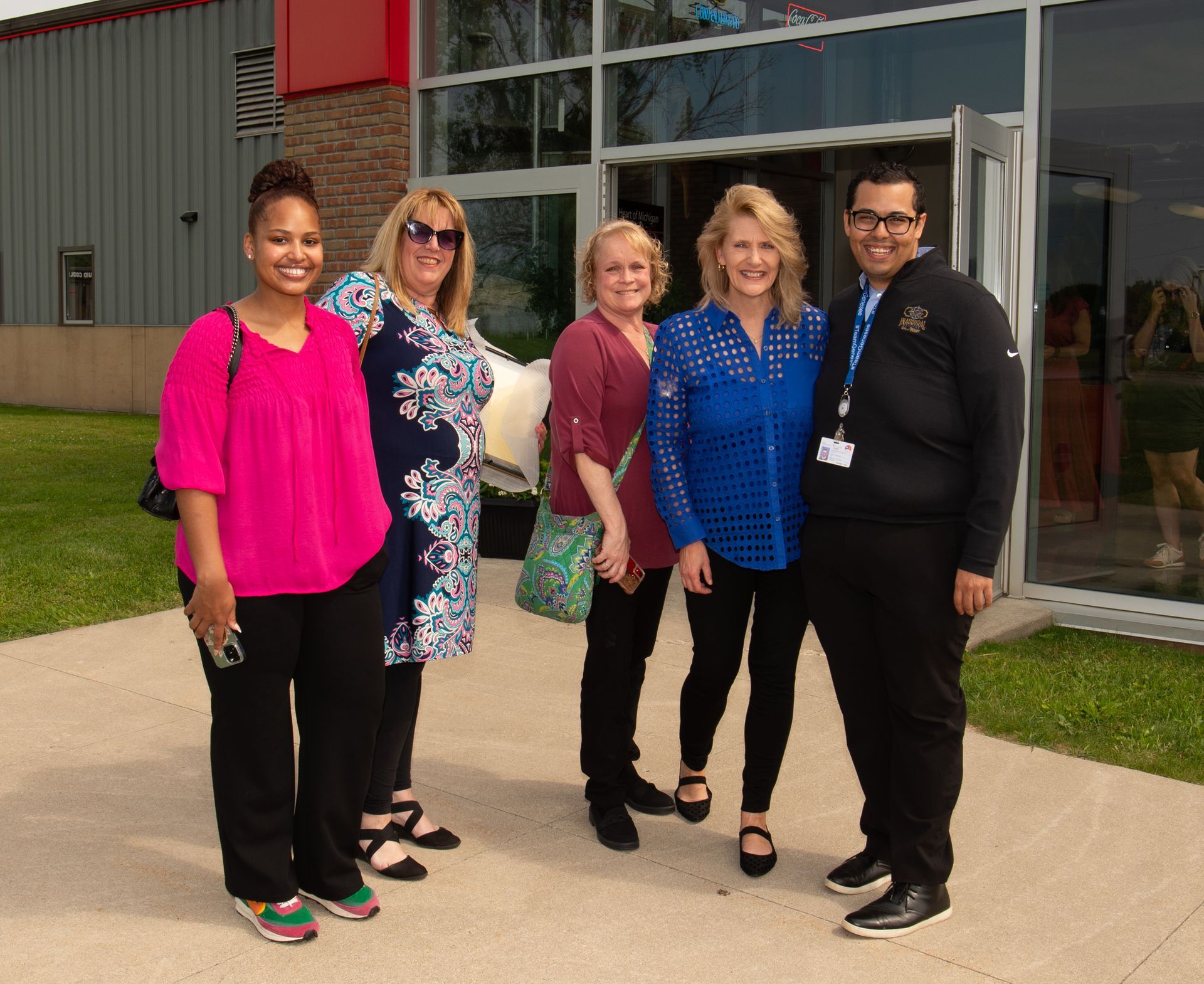 A group of people are posing for a picture in front of a building.