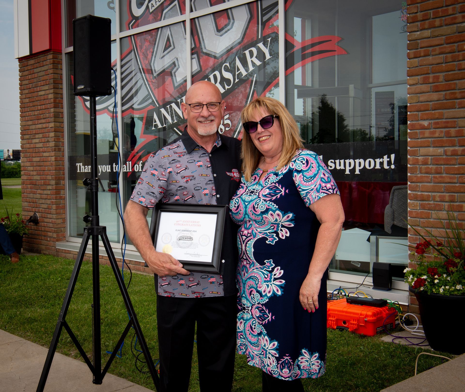 A man and woman standing in front of a 40th anniversary sign