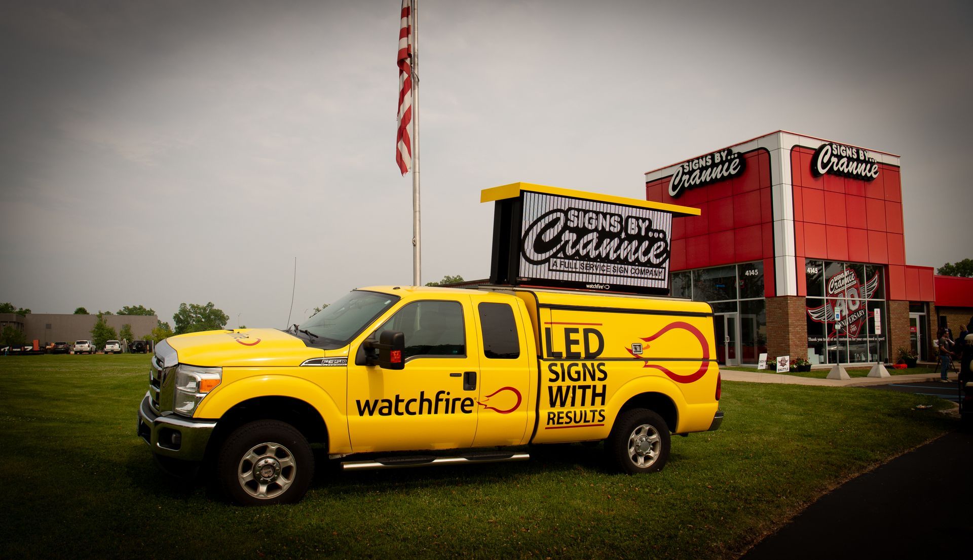 A yellow watchfire truck is parked in front of a building