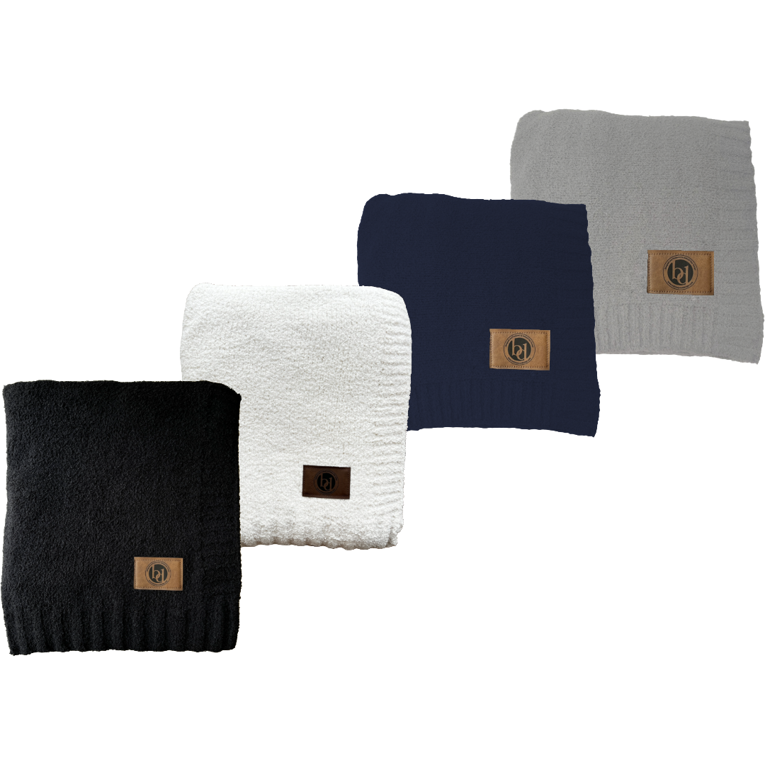 Four different colored scarves are lined up in a row on a white background.